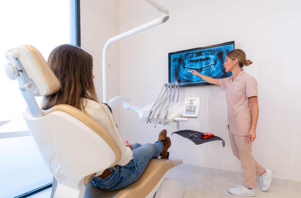 A dentist reviews their patient's X-ray results with them.