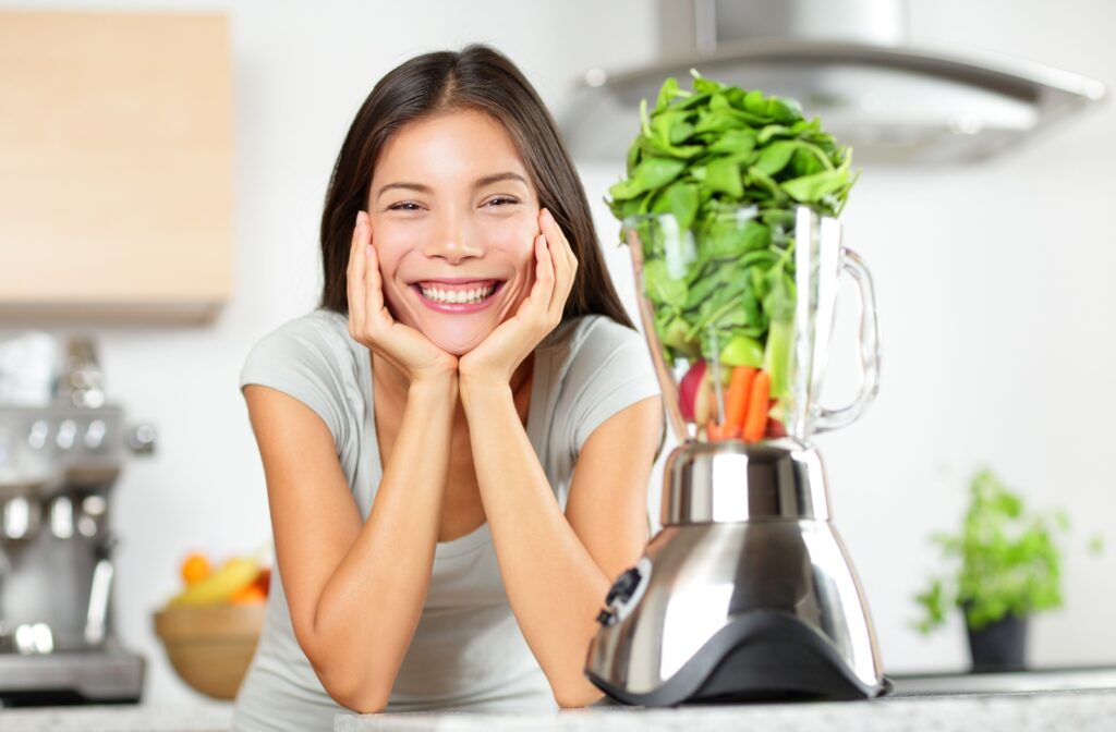 A patient with a beautiful smile preparing to blend a smoothie.