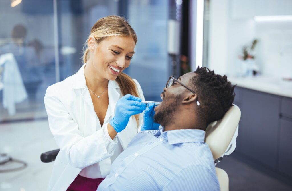 A dentist examines their patient's throat for tonsil stones.